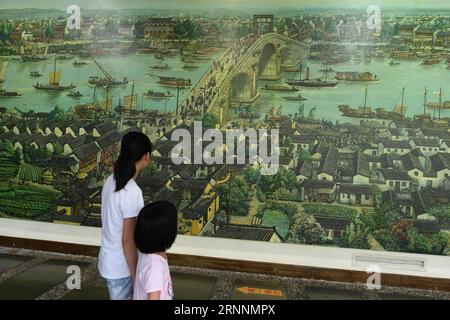 (170721) -- HANGZHOU, le 21 juillet 2017 -- des enfants regardent une peinture murale sur le pont de Gongchen au Musée du Grand Canal à Hangzhou, dans la province du Zhejiang de l'est de la Chine, le 20 juillet 2017. Une ceinture culturelle et pittoresque, comprenant des musées, des zones culturelles et créatives, des reliques historiques et des rues anciennes, s'est formée le long de la section de 12 kilomètres du Grand Canal Pékin-Hangzhou dans le district de Gongshu à Hangzhou. )(MCG)(zt) CHINA-HANGZHOU-GRAND CANAL (CN) HuangxZongzhi PUBLICATIONxNOTxINxCHN Hangzhou juillet 21 2017 enfants Voir une peinture murale sur le pont Gong Chen AU Musée du Grand Canal à Hangzh Banque D'Images