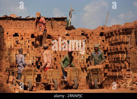 (170724) -- SRINAGAR, 24 juillet 2017 -- les travailleurs migrants chargent des briques sur leurs charrettes à main dans un four à briques dans un village du district de Budgam à environ 20 km au Sud-Ouest de Srinagar, capitale estivale du Cachemire contrôlé par les Indiens, le 24 juillet 2017. Le Cachemire sous contrôle indien compte plus de 300 fours en briques. Les experts en environnement disent que le grand nombre de fours à briques près des habitations dans le Cachemire sous contrôle indien posent un grave danger pour la vie et la santé des gens. (dtf) KASHMIR-SRINAGAR-BRICK FOUR INDUSTRY JavedxDar PUBLICATIONxNOTxINxCHN Srinagar juillet 24 2017 main-d'œuvre immigrée charge des briques SUR leur charrette à main Banque D'Images