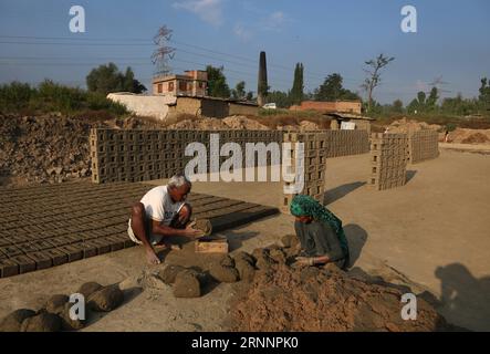 (170724) -- SRINAGAR, 24 juillet 2017 -- les travailleurs migrants travaillent dans un four à briques dans un village du district de Budgam à environ 20 km au sud-ouest de Srinagar, capitale estivale du Cachemire contrôlé par les Indiens, le 24 juillet 2017. Le Cachemire sous contrôle indien compte plus de 300 fours en briques. Les experts en environnement disent que le grand nombre de fours à briques près des habitations dans le Cachemire sous contrôle indien posent un grave danger pour la vie et la santé des gens. (dtf) KASHMIR-SRINAGAR-BRICK FOUR INDUSTRY JavedxDar PUBLICATIONxNOTxINxCHN Srinagar juillet 24 2017 travail immigrant dans un four à briques DANS un village du district de Budgam Abo Banque D'Images