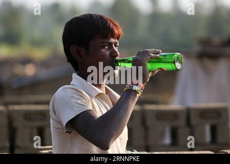 (170724) -- SRINAGAR, le 24 juillet 2017 -- Un travailleur migrant boit une boisson froide alors qu'il travaille dans un four à briques dans un village du district de Budgam à environ 20 km au Sud-Ouest de Srinagar, capitale estivale du Cachemire contrôlé par l'Inde, le 24 juillet 2017. Le Cachemire sous contrôle indien compte plus de 300 fours en briques. Les experts en environnement disent que le grand nombre de fours à briques près des habitations dans le Cachemire sous contrôle indien posent un grave danger pour la vie et la santé des gens. (dtf) KASHMIR-SRINAGAR-BRICK FOUR INDUSTRY JavedxDar PUBLICATIONxNOTxINxCHN Srinagar juillet 24 2017 un travailleur immigrant boit une boisson froide comme lui Banque D'Images