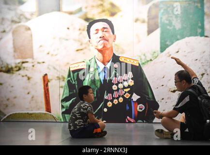 (170730) -- PÉKIN, le 30 juillet 2017 -- Un visiteur s'explique alors qu'un garçon écoute devant une œuvre exposée dans une exposition de photos marquant le 90e anniversaire de l'Armée populaire de libération (APL) à Pékin, capitale de la Chine, le 30 juillet 2017. )(clq) CHINA-BEIJING-PLA-ANNIVERSARY-EXHIBITION(CN) ChenxYehua PUBLICATIONxNOTxINxCHN Beijing juillet 30 2017 un visiteur explique comme un garçon écoute devant une œuvre exposée dans une exposition de photos marquant le 90e anniversaire des célébrités S Liberation Army PLA à Beijing capitale de la Chine juillet 30 2017 CLQ China Beijing PLA Exhibition CN ChenxYehu Banque D'Images