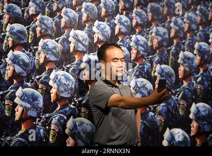 (170730) -- PÉKIN, le 30 juillet 2017 -- Un visiteur prend un selfie devant une œuvre exposée dans une exposition de photos marquant le 90e anniversaire de l'Armée populaire de libération (APL) à Pékin, capitale de la Chine, le 30 juillet 2017. )(clq) CHINA-BEIJING-PLA-ANNIVERSARY-EXHIBITION(CN) ChenxYehua PUBLICATIONxNOTxINxCHN Beijing juillet 30 2017 un visiteur prend un selfie devant une œuvre exposée dans une exposition de photos marquant le 90e anniversaire des célébrités S Liberation Army PLA à Beijing capitale de la Chine juillet 30 2017 CLQ China Beijing PLA Exhibition CN ChenxYehua PUBLICATIONxNOTxINxC Banque D'Images