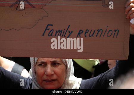 (170802) -- ATHÈNES, 2 août 2017 -- Une femme tenant un conseil de réunion familiale manifeste devant l'ambassade d'Allemagne dans le centre d'Athènes, capitale de la Grèce, le 2 août 2017. Des centaines de réfugiés vivant dans des camps d'accueil, des hôtels et des appartements loués à travers la Grèce ont organisé mercredi une manifestation pacifique symbolique contre la lenteur des relocalisations vers l'Allemagne pour le regroupement familial.) GRÈCE-ATHÈNES-RÉFUGIÉS-PROTESTATION MariosxLolos PUBLICATIONxNOTxINxCHN Athènes 2 2017 août une femme tenant une manifestation du Conseil de réunion de famille devant l'ambassade d'Allemagne dans le centre d'Athènes capitale de la Grèce LE 2 2017 août Banque D'Images