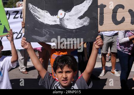 (170802) -- ATHÈNES, 2 août 2017 -- Un garçon tenant une colombe de la paix manifeste devant l'ambassade d'Allemagne dans le centre d'Athènes, capitale de la Grèce, le 2 août 2017. Des centaines de réfugiés vivant dans des camps d'accueil, des hôtels et des appartements loués à travers la Grèce ont organisé mercredi une manifestation pacifique symbolique contre la lenteur des relocalisations vers l'Allemagne pour le regroupement familial.) GRÈCE-ATHÈNES-RÉFUGIÉS-PROTESTATION MariosxLolos PUBLICATIONxNOTxINxCHN Athènes août 2 2017 un garçon tenant une manifestation de Conseil de colombe de paix devant l'ambassade d'Allemagne dans la capitale centrale d'Athènes de la Grèce LE 2 2017 août des centaines de R. Banque D'Images