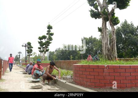 (170803) -- DHAKA, 3 août 2017 -- la photo prise le 3 août 2017 montre des ouvriers travaillant sous des bonsaïs chinois plantés à Dhaka, capitale du Bangladesh. Le Bangladesh a importé des dizaines de ficus bonsaïs de Chine et les a plantés le long d une route principale menant au principal aéroport du pays dans la capitale. (lrz) BANGLADESH-DHAKA-CHINESE-BONSAI SalimxReza PUBLICATIONxNOTxINxCHN Dhaka août 3 2017 la photo prise LE 3 2017 août montre des ouvriers travaillant avec des bonsaïs chinois plantés à Dhaka capitale du Bangladesh le Bangladesh a importé des dizaines de bonsaïs Ficus de Chine et les a plantés Banque D'Images