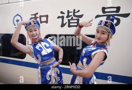 (170803) -- HOHHOT, 3 août 2017 -- des artistes posent pour une photo avec le train à grande vitesse à la gare ferroviaire d'Ulanqab à Ulanqab, dans la région autonome de Mongolie intérieure du nord de la Chine, le 3 août 2017. Le premier chemin de fer à grande vitesse dans la région autonome de Mongolie intérieure reliant Hohhot et Ulanqab a commencé à fonctionner jeudi. Le chemin de fer de 126 kilomètres de long fait partie du chemin de fer à grande vitesse qui relie Hohhot à Zhangjiakou dans la province du Hebei, ville co-hôte des Jeux Olympiques d’hiver de 2022. Et le temps de trajet entre Ulanqab et Hohhot sera raccourci à 40 minutes.) (XZY) CHINE-MONGOLIE INTÉRIEURE-GRANDE VITESSE RA Banque D'Images