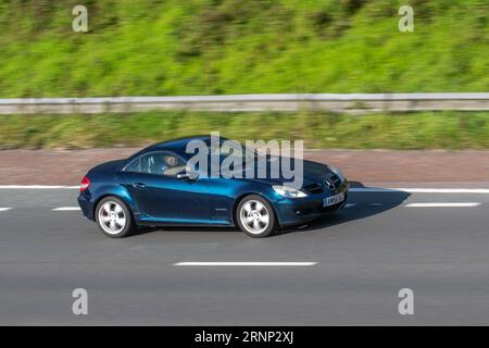 2006 Bleu Mercedes-Benz SLK 200 Kompressor Auto se déplaçant à grande vitesse sur l'autoroute M6 dans le Grand Manchester, Royaume-Uni Banque D'Images