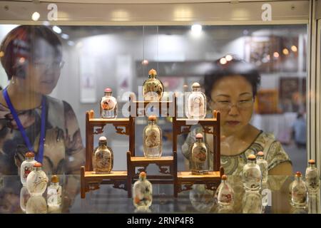 (170810) -- BEIJING , 10 août 2017 -- les visiteurs voient des bouteilles de tabac à priser exposées lors de l'exposition de littérature et d'art de Beijing à Beijing, capitale de la Chine, le 10 août 2017. La 5e exposition de littérature et d'art de Pékin a été inaugurée jeudi au National Agriculture Exhibition Centre de Pékin. Plus de 3 500 œuvres de peinture, calligraphie, théâtre, photographie et art populaire sont exposées ici. ) (zx) CHINA-BEIJING-LITERATURE AND ART EXHIBITION (CN) JinxLiangkuai PUBLICATIONxNOTxINxCHN Beijing août 10 2017 visiteurs Voir les bouteilles de tabac exposées lors de l'exposition de littérature et d'art de Pékin à Beijin Banque D'Images