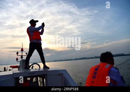 (170811) -- ANQING, 11 août 2017 -- des patrouilleurs auxiliaires travaillent dans la réserve naturelle de marsouin sans finesse à Anqing, dans la province d Anhui de l est de la Chine, 10 août 2017. Une brigade de patrouille auxiliaire, dont 6 anciens pêcheurs, a commencé sa mission le 2017 juin pour protéger les 60 marsouins sans ailettes le long de la section de 60 kilomètres du fleuve Yangtsé dans la province. L'application téléphonique est utilisée dans leurs missions de routine pour suivre et observer la vie des mammifères ressemblant aux dauphins, fournir la protection nécessaire et surveiller le polluant et la pêche illégale dans la réserve. ) (clq) CHINE-ANHUI-ANQING-ÉCOLOGIE (CN) Liux Banque D'Images