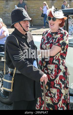 Morecambe, Lancashire - 2 septembre 2023 - les visiteurs ont apprécié le festival Vintage by the Sea de Morecambe samedi. Beaucoup d’entre eux sont venus habillés de vêtements vintage et se sont imprégnés de l’atmosphère. Un homme s'est reposé à l'ombre de sa voiture d'époque en lisant un journal alors que le soleil flamboyant se baissait. Crédit : Arrêter Press Media/Alamy Live News Banque D'Images