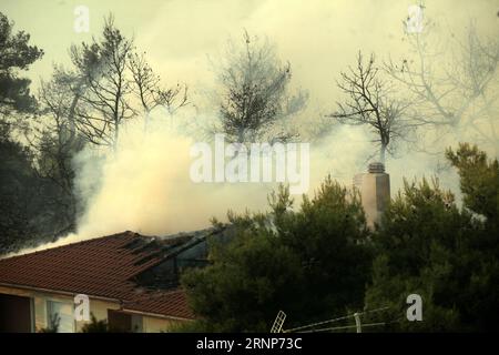 (170814) -- ATHÈNES, 14 août 2017 -- de la fumée s'élève du toit d'une maison après qu'un feu de forêt a éclaté dans une zone forestière dans la banlieue nord athénienne de Kalamos le 13 août 2017. Un incendie de forêt majeur a éclaté dans la banlieue d'Athènes dimanche, causant d'importants dommages, selon l'Agence de presse d'Athènes. )(yk) GRÈCE-ATHÈNES-FEUX DE FORÊT ChristosxBonis PUBLICATIONxNOTxINxCHN 170814 Athènes août 14 2017 de la fumée s'élève d'un toit d'une maison après qu'un sauvage se soit déclaré dans une zone forestière dans la banlieue nord de Kalamos d'Athènes LE 13 2017 août, un incendie de forêt majeur s'est déclaré dimanche dans la banlieue d'Athènes caus Banque D'Images