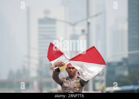 (170815) -- JAKARTA, 15 août 2017 -- un policier indonésien attire le drapeau avant l'anniversaire du 72e jour de l'indépendance indonésienne à Jakarta, Indonésie, le 15 août 2017. L'anniversaire du jour de l'indépendance indonésienne tombe le 17 août. ) (gj) INDONESIA-JAKARTA-ATTRACTION-INDEPENDANCE DAY VerixSanovri PUBLICATIONxNOTxINxCHN 170815 Jakarta 15 2017 août à un policier indonésien effectue une attraction de drapeau avant l'anniversaire du 72e jour de l'indépendance indonésienne à Jakarta Indonésie 15 2017 août l'anniversaire du jour de l'indépendance indonésienne tombe le 17 août GJ Indonesia Jaka Banque D'Images