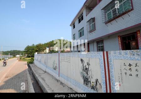 (170816) -- GANZHOU, 16 août 2017 -- Un mur avec des peintures est vu dans le village de Gufang dans le township de Wenwuba dans le comté de Huichang, ville de Ganzhou, province de Jiangxi dans l'est de la Chine, le 28 juillet 2017. Depuis 2016, les autorités locales du village de Gufang prennent des mesures ciblées pour lutter contre la pauvreté. Les infrastructures, telles que les routes, les maisons et les lampes solaires, ont été construites et de nouvelles industries ont été introduites dans le village, ce qui a radicalement changé le village. Les étangs à poissons, les serres ainsi que les vergers ont stimulé l'économie agricole locale. L'amélioration de l'environnement dans le village a également attiré de nombreux migras Banque D'Images