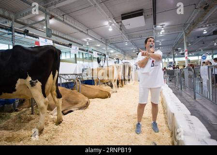 (170819) -- TORONTO (CANADA), le 19 août 2017 -- Un membre du personnel de Dairy Farmers of Ontario présente les procédures de production laitière à l'exposition nationale canadienne à Toronto, Canada, le 18 août 2017. Les États-Unis ont ouvert mercredi la renégociation de l’Accord de libre-échange nord-américain (ALENA), vieux de 23 ans, avec une déclaration selon laquelle ils veulent des changements majeurs à l’accord qui modifient la balance commerciale. Toutefois, les propriétaires d’entreprises canadiennes espèrent que les négociateurs américains seront réceptifs au maintien, sinon à l’amélioration, de la circulation actuelle des marchandises et des travailleurs à la frontière. Bien que le canadien Banque D'Images