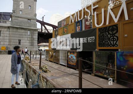 (170824) -- CHICAGO, 24 août 2017 -- Un visiteur regarde des œuvres d'art du Floating Museum amarré au bord de la rivière à Chicago, aux États-Unis, le 23 août 2017. Célébrant le passé industriel de la rivière, Floating Museum transforme une barge en une galerie mobile esthétiquement saisissante remplie de caisses d art présentant des œuvres créées par des artistes locaux et nos collaborateurs. Floating Museum existe dans le continuum des artistes examinant leur rapport aux institutions, et répond à l'évolution des musées ; allant du cabinet de curiosités ou Wunderkabinett entre le seizième et le huitième Banque D'Images