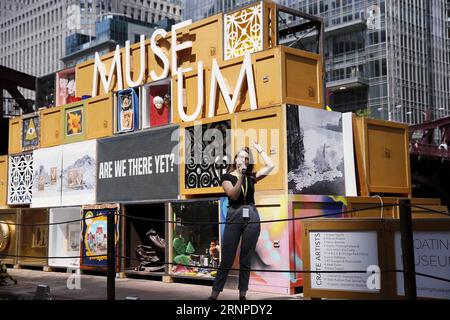 (170824) -- CHICAGO, 24 août 2017 -- Un volontaire présente l'idée du musée flottant aux visiteurs de Chicago, aux États-Unis, le 23 août 2017. Célébrant le passé industriel de la rivière, Floating Museum transforme une barge en une galerie mobile esthétiquement saisissante remplie de caisses d art présentant des œuvres créées par des artistes locaux et nos collaborateurs. Floating Museum existe dans le continuum des artistes examinant leur rapport aux institutions, et répond à l'évolution des musées ; allant du cabinet de curiosités ou Wunderkabinett entre le seizième et le dix-huitième centuri Banque D'Images