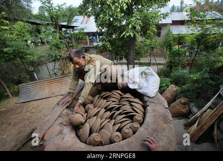 (170828) -- SRINAGAR, 28 août 2017 -- Un potier cachemiri ajuste des pots en terre dans un four avant le processus de chauffage dans un village du district de Budgam, à environ 25 km au sud-ouest de Srinagar, capitale estivale du Cachemire contrôlé par les Indiens, 28 août 2017. La communauté potter dans le Cachemire contrôlé par les Indiens perd ses moyens de subsistance en raison de l'évolution des modes de vie des habitants qui ne préfèrent plus les produits de poterie. Les enfants des potiers cachemiris ne prennent pas non plus à la profession car ils ne trouvent pas cela suffisant leurs besoins. ) (zw) KASHMIR-SRINAGAR-POTTERY JavedxDar PUBLICATIONxNOTxINxCHN Srinagar août 28 2017 Banque D'Images