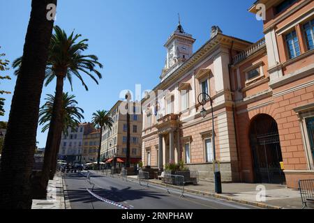 L'hôtel de ville d'Ajaccio encadrée de feuilles de palmiers. Ajaccio est la capitale de l'île de Corse du Sud, France. Banque D'Images