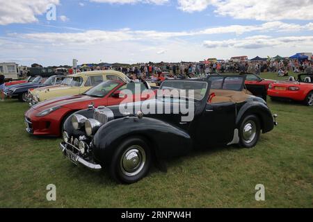 Une Triumph Roadster noire vintage exposée aux côtés d'autres voitures anciennes, c1940s. Le rallye de voitures de Gosport est organisé par le Rotary Club local et a lieu à Stokes Bay le lundi jour férié du mois d'août. L'événement de cette année, offrant une journée en famille bon marché, était le soixante-dixième et a accueilli des voitures et des motos anciennes, une ferme pour enfants, des stands, des rafraîchissements et une arène qui a fourni diverses formes de divertissement. Banque D'Images
