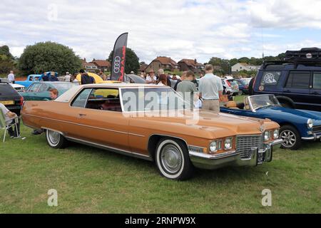 Orange c1970s Cadillac coupé DeVille à l'affiche. Le rallye de voitures de Gosport est organisé par le Rotary Club local et a lieu à Stokes Bay le lundi jour férié du mois d'août. L'événement de cette année, offrant une journée en famille bon marché, était le soixante-dixième et a accueilli des voitures et des motos anciennes, une ferme pour enfants, des stands, des rafraîchissements et une arène qui a fourni diverses formes de divertissement. Banque D'Images