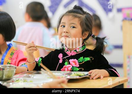 (170910) -- BEIJING, 10 septembre 2017 -- PAN Chengyue, une jeune fille de 4 ans du groupe ethnique Miao, prend un déjeuner gratuit au Kindergarten n° 13 de la communauté Kaihuai, qui a été construit pour les enfants réinstallés dans des zones frappées par la pauvreté, dans la ville de Kaili, Miao et la préfecture autonome de Dong de Qiandongnan, dans le sud-ouest de la Chine, province du Guizhou, le 6 septembre 2017. Le programme de nutrition a bénéficié aux enfants d'âge préscolaire dans la zone rurale de Kaili depuis le printemps de cette année, avec le petit déjeuner et le déjeuner gratuits offerts aux enfants dans les jardins d'enfants ruraux et les jardins d'enfants pour les enfants déplacés des zones frappées par la pauvreté.) CH. HEBDOMADAIRE Banque D'Images