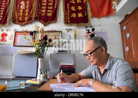 (170914) -- NANCHANG, 14 septembre 2017 -- He Xingwu travaille dans son bureau dans une école spéciale de Nanchang, dans la province du Jiangxi dans l'est de la Chine, le 13 septembre 2017. L’enseignant de 74 ans He Xingwu travaille dans l’école Speical depuis 23 ans. Il a perdu l'ouïe à l'âge de huit ans en raison d'une mauvaise consommation de drogues. En 1994, lui et son ami fondèrent l'école après sa retraite. Plus de 300 élèves malentendants et malentendants ont obtenu leur diplôme de l'école. ) (zkr)(zt) CHINE-NANCHANG-ENSEIGNANT MALENTENDANT(CN) PengxZhaozhi PUBLICATIONxNOTxINxCHN Banque D'Images