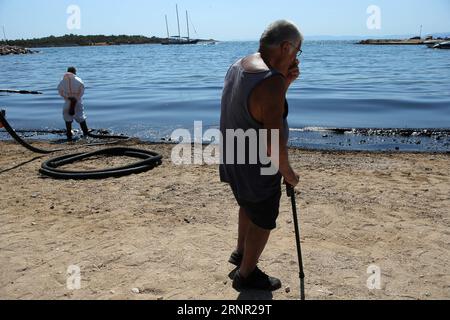 (170914) -- ATHÈNES, 14 septembre 2017 -- Un résident local se trouve près d'une plage polluée par les hydrocarbures de Glyfada, une banlieue sud-est d'Athènes, capitale de la Grèce, le 14 septembre 2017. Une importante opération de nettoyage qui était en cours jeudi pour faire face à une marée noire qui s'est propagée dans une grande partie du golfe Saronique durera environ trois semaines, a déclaré le ministre grec de la marine marchande Panagiotis Kouroumblis lors d'un point de presse. La crise environnementale a éclaté dimanche après le naufrage du petit pétrolier Agia Zoni II transportant environ 2 500 tonnes de pétrole, qui a été ancré au large de l'île Salamina sous un encore peu clair Banque D'Images