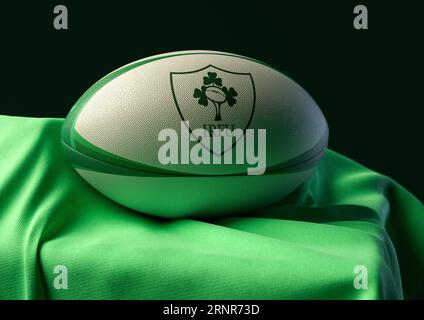 2 septembre 2023 - Bristol, Royaume-Uni : rendu 3D d'un ballon de rugby imprimé avec le logo de rugby irlandais reposant sur un tissu vert drapé Banque D'Images