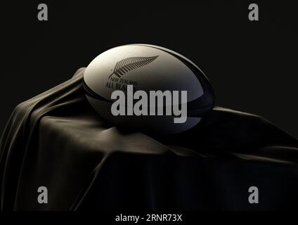 2 septembre 2023 - Bristol, Royaume-Uni : rendu 3D d'un ballon de rugby imprimé avec le logo de rugby New Zealand All Blacks reposant sur un blac drapé Banque D'Images