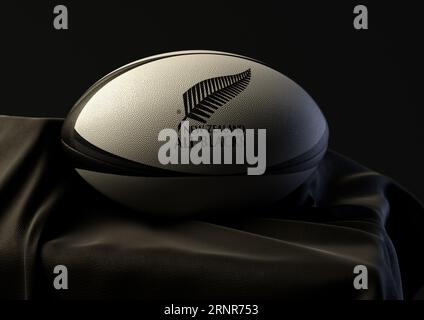 2 septembre 2023 - Bristol, Royaume-Uni : rendu 3D d'un ballon de rugby imprimé avec le logo de rugby New Zealand All Blacks reposant sur un blac drapé Banque D'Images