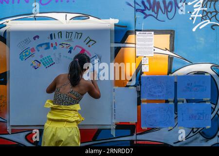 Londres, Royaume-Uni. 2 septembre 2023. Les artistes créent de l'art comme les gens regardent sur une palissade couverte de graffitis - Camden inspire festival de musique live, de poésie, d'art de rue et de peinture murale organisé par Camden Open Air Gallery. Crédit : Guy Bell/Alamy Live News Banque D'Images