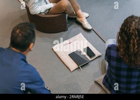 Photo d'une tablette à côté d'un téléphone portable avec des hommes d'affaires assis dans l'amphithéâtre Banque D'Images