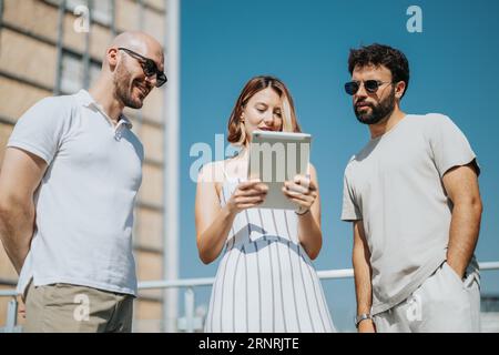 Jeunes architectes et hommes d'affaires collaborant à l'extérieur, discutant de la conception architecturale avec plan sur la table, créant un plan de construction moderne. Banque D'Images