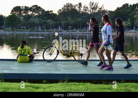 (171007) -- PHUKET, 7 octobre 2017 -- les gens passent devant un vélo de partage ofo dans un parc public de Phuket, Thaïlande, 5 octobre 2017. La société chinoise de partage de vélos sans quai ofo a fourni plus de 1 000 vélos dans les principaux endroits de Phuket fin septembre et a offert un essai gratuit de 1 mois sans frais de dépôt. Maintenant, le service de partage de vélos a profité aux résidents locaux et aux touristes. Les frais de service réguliers d'OFO seront facturés à 5 Baht pour 30 minutes d'utilisation, avec des frais de dépôt de 99 Baht. )(zhf) THAÏLANDE-PHUKET-CHINE-BIKE-SHARING-OFO LixMangmang PUBLICATIONxNOTxINxCHN Banque D'Images