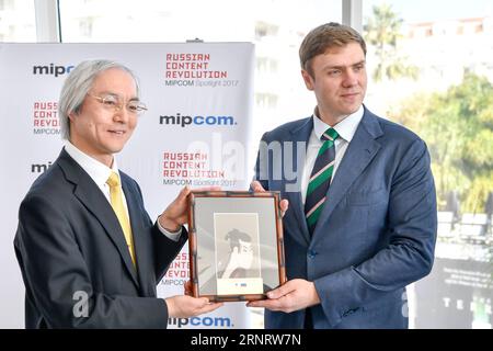 (171016) -- CANNES, 16 octobre 2017 -- Masahiko Tomonaga (à gauche), vice-ministre de la coordination des politiques du ministère japonais des Affaires intérieures et des Communications, au nom du Japon, le pays d'honneur du MIPCOM 2016, offre un cadeau à Mikhail Mamonov, directeur général de la promotion du commerce international du Centre russe d'exportation, à Cannes, France le 16 octobre 2017. Le MIPCOM (International Market of Communications programmes) de quatre jours 2017, qui met en avant les produits de communication russes cette année, a débuté lundi. ) (lrz) FRANCE-CANNES-MIPCOM-INAUGURATION ChenxYichen PUBLICATIONxNOTxINxCHN Banque D'Images