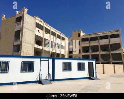 (171017) -- ALEP, 17 octobre 2017 -- une photo prise le 12 octobre 2017 montre des salles de classe préfabriquées simples dans l'école Ibrahim al-Tanbi, Alep, Syrie. Le bâtiment de l'école a été déchiré en pièces, mais les élèves de différents âges étudiaient dans de simples salles de classe préfabriquées installées par le gouvernement dans la cour. Autrefois utilisées par les rebelles comme bases, les écoles de la ville d ' Alep ont retrouvé leur fonction initiale de lieu d ' éducation pour les enfants. (psw) SYRIE-ALEP-ÉDUCATION-SALLES DE CLASSE PRÉFABRIQUÉES ZhengxYihan PUBLICATIONxNOTxINxCHN Banque D'Images