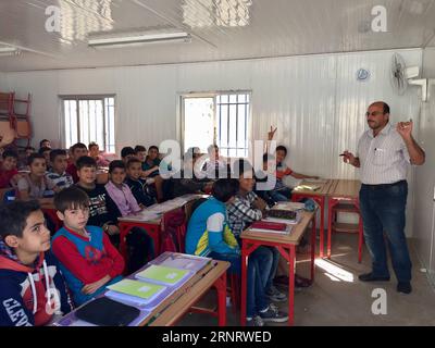 (171017) -- ALEP, 17 octobre 2017 -- des élèves suivent un cours dans une salle de classe préfabriquée simple de l'école Ibrahim al-Tanbi, Alep, Syrie, le 12 octobre 2017. Le bâtiment de l'école a été déchiré en pièces, mais les élèves de différents âges étudiaient dans de simples salles de classe préfabriquées installées par le gouvernement dans la cour. Autrefois utilisées par les rebelles comme bases, les écoles de la ville d ' Alep ont retrouvé leur fonction initiale de lieu d ' éducation pour les enfants. (psw) SYRIE-ALEP-ÉDUCATION-SALLES DE CLASSE PRÉFABRIQUÉES ZhengxYihan PUBLICATIONxNOTxINxCHN Banque D'Images