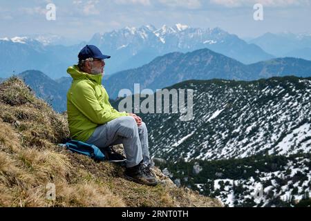 Randonneur, senior, 65 ans, se reposant sur le sommet du Rotwand, derrière Wilder Kaiser, Spitzingsee, Mangfall Mountains, haute-Bavière, Tyrol, Allemagne Banque D'Images