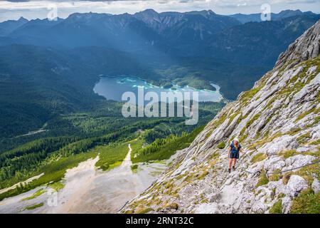 Via ferrata sur la Riffelscharte, randonneur dans les montagnes, vue sur le lac Eibsee et Werdenfelser Land, les montagnes de Wetterstein, Garmisch-Patenkirchen Banque D'Images
