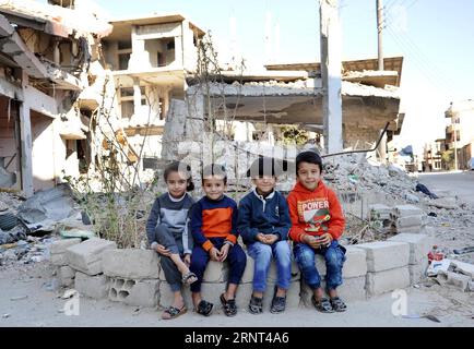 (171029) -- HOMS, 29 octobre 2017 -- des enfants posent dans un quartier ravagé de la ville d'al-Qarayatayn, province de Homs, centre de la Syrie, le 29 octobre 2017. L’armée syrienne a libéré la ville le 21 octobre 2017 après que les militants de l’État islamique (EI) l’aient prise d’assaut pour la deuxième fois le mois dernier. SYRIE-HOMS-VILLE LIBÉRÉE-VIE QUOTIDIENNE AMMARXSAFARJALANI PUBLICATIONXNOTXINXCHN Banque D'Images