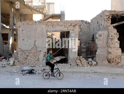 (171029) -- HOMS, 29 octobre 2017 -- Un garçon monte à vélo dans un quartier ravagé de la ville d'al-Qarayatayn, province de Homs, centre de la Syrie, le 29 octobre 2017. L’armée syrienne a libéré la ville le 21 octobre 2017 après que les militants de l’État islamique (EI) l’aient prise d’assaut pour la deuxième fois le mois dernier. SYRIE-HOMS-VILLE LIBÉRÉE-VIE QUOTIDIENNE AMMARXSAFARJALANI PUBLICATIONXNOTXINXCHN Banque D'Images