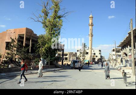 (171029) -- HOMS, 29 octobre 2017 -- des gens marchent dans un quartier ravagé de la ville d'al-Qarayatayn, province de Homs, centre de la Syrie, le 29 octobre 2017. L’armée syrienne a libéré la ville le 21 octobre 2017 après que les militants de l’État islamique (EI) l’aient prise d’assaut pour la deuxième fois le mois dernier. SYRIE-HOMS-VILLE LIBÉRÉE-VIE QUOTIDIENNE AMMARXSAFARJALANI PUBLICATIONXNOTXINXCHN Banque D'Images