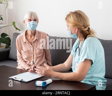 Infirmière femme aînée conversant maison de soins infirmiers Banque D'Images