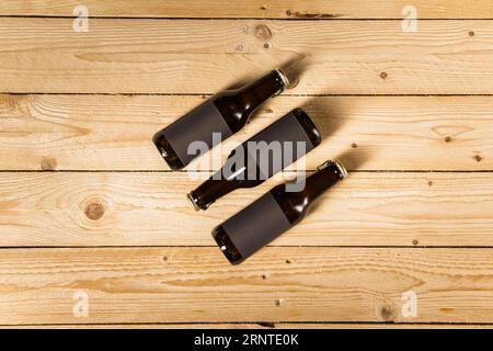 Vue surélevée trois bouteilles de bière fond en bois Banque D'Images