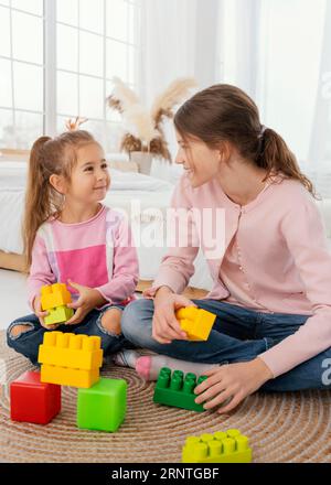 Vue de face deux sœurs jouant avec des jouets Banque D'Images