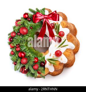 Collage créatif de belle couronne de Noël et gâteau savoureux sur fond blanc Banque D'Images