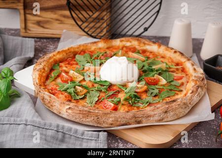 Pizza savoureuse avec du fromage Burrata sur table Banque D'Images