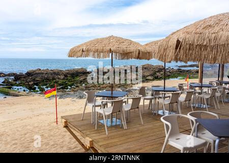 Bar élégant sur la plage de Porto Portugal avec parasols en roseau Banque D'Images