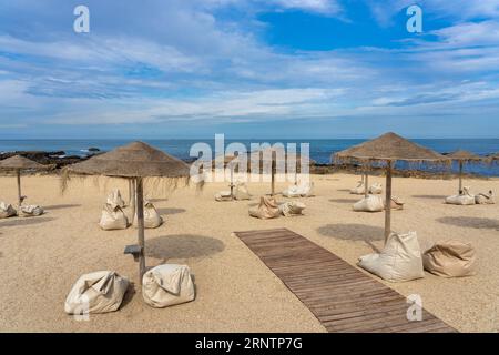 Bar élégant sur la plage de Porto Portugal avec parasols en roseau Banque D'Images