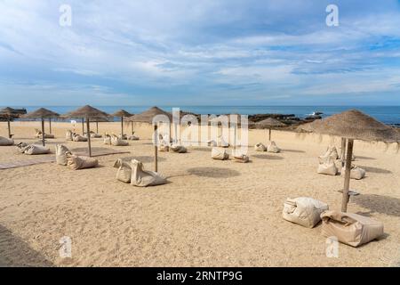 Bar élégant sur la plage de Porto Portugal avec parasols en roseau Banque D'Images